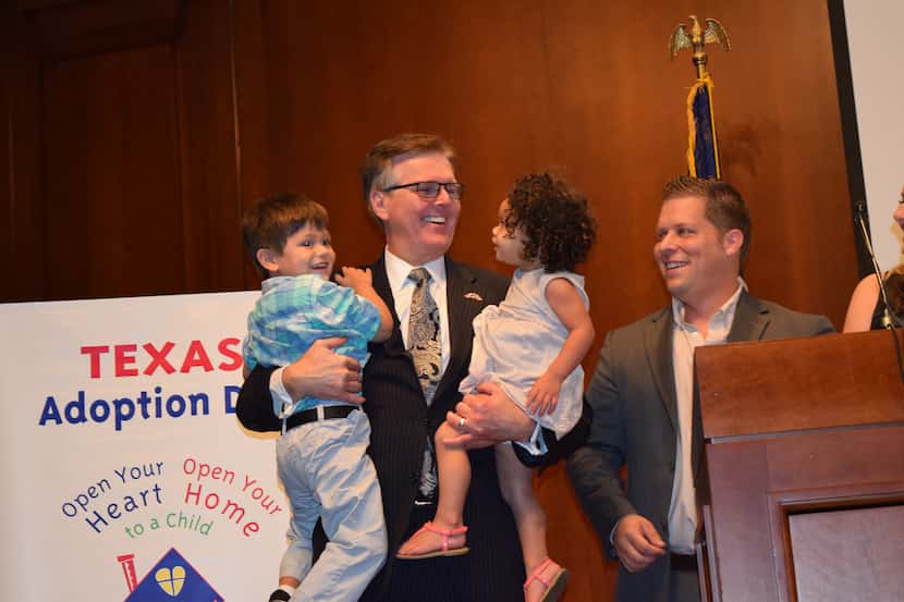 Texas Lt. Gov. Dan Patrick scoops up foster children Ricky (left) and Reese Piccioti, while...