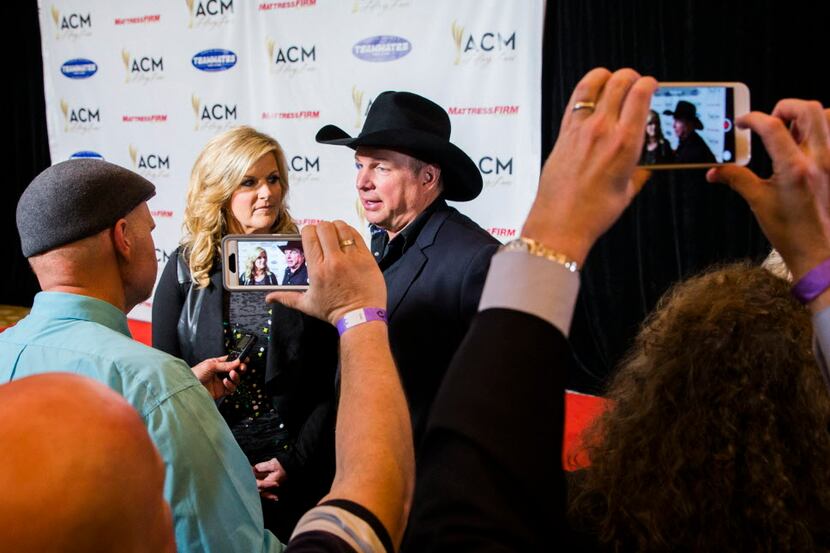 Country music stars Trisha Yearwood and Garth Brooks answer media questions on the red carpet.