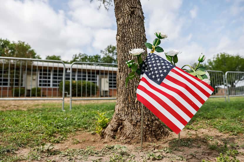 An American flag along with white roses is seen in front of Robb Elementary School where 19...