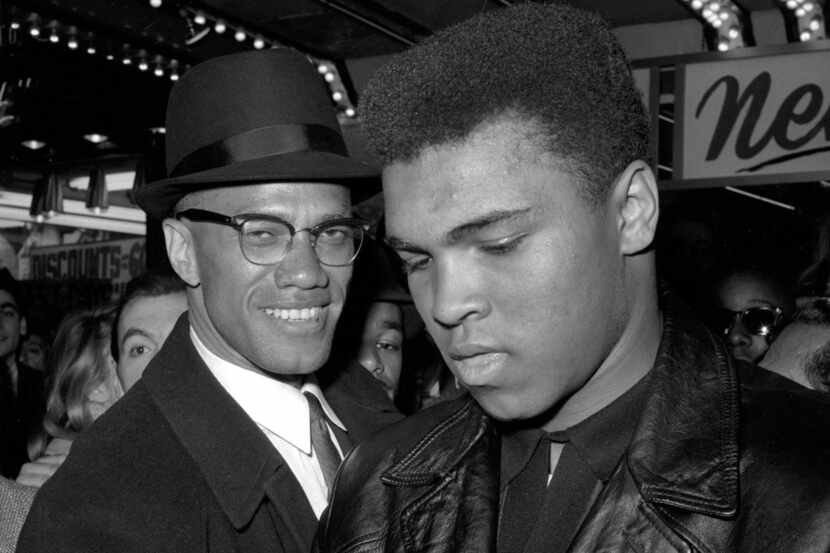 
Muhammad Ali stands with Malcolm X in 1964 outside the Trans-Lux Newsreel Theater on...