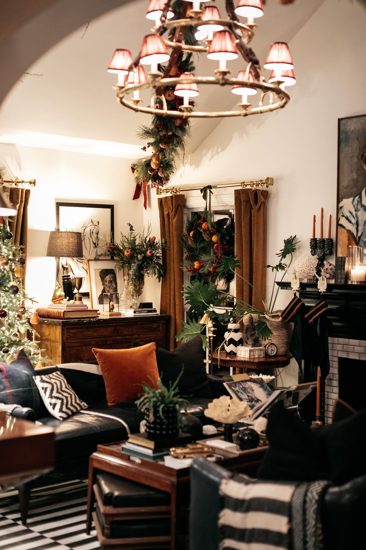 In the living room, Burkle came up with the idea to hang garland from the chandelier to the...