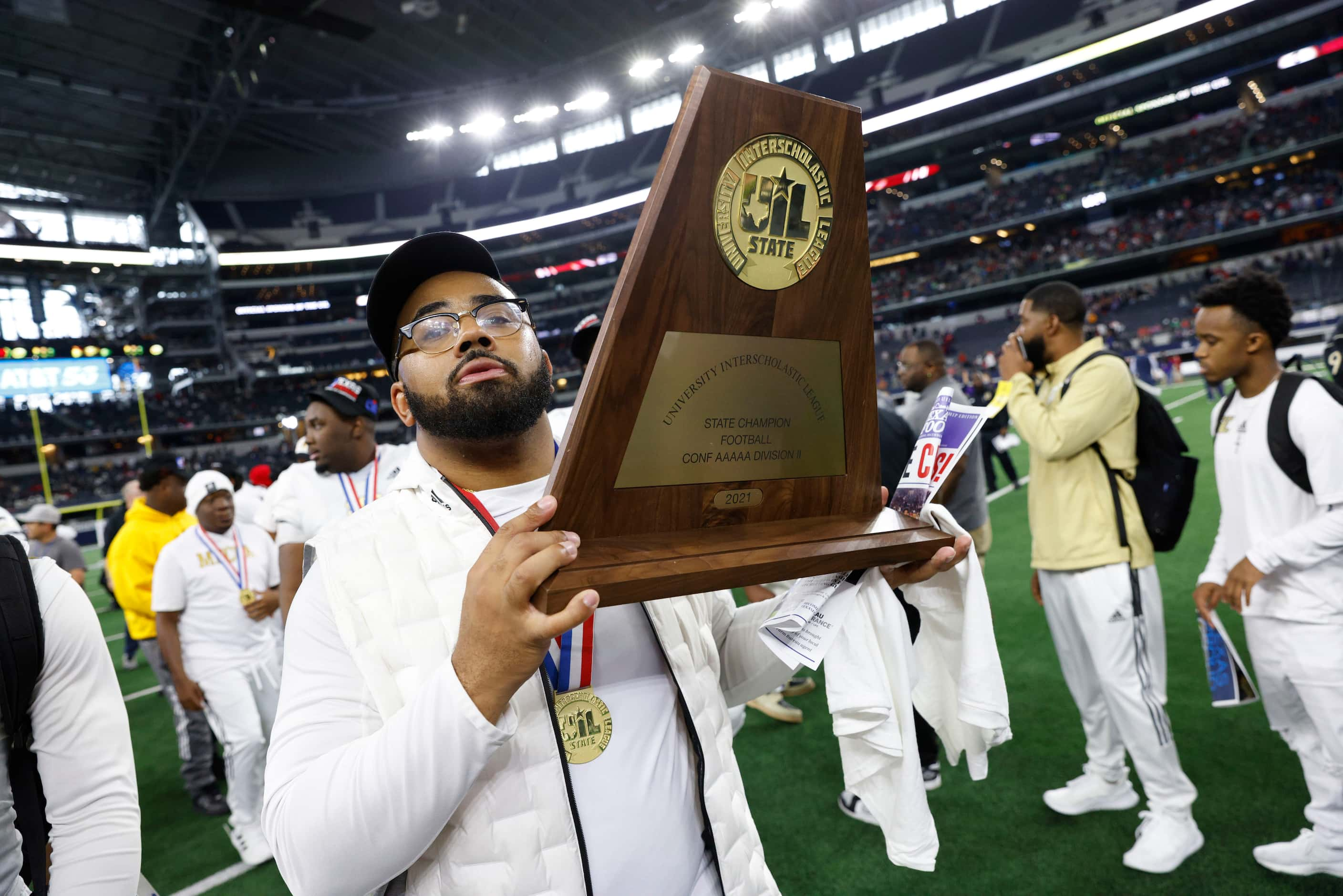 South Oak Cliff assistant coach Domenic Spencer raises the championship trophy after the...