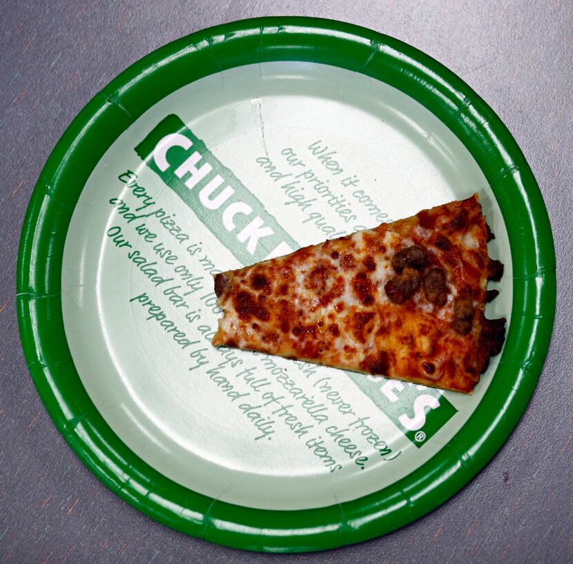 A partially eaten slice of pizza lays on a table at Chuck E. Cheese's Thursday, January 16,...