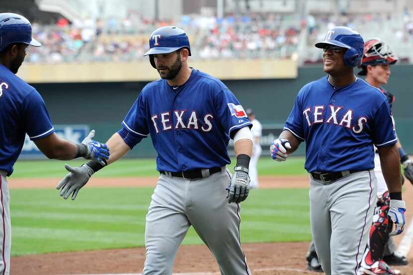 Elvis Andrus #1 of the Texas Rangers congratulates teammates Mitch Moreland #18 and Adrian...