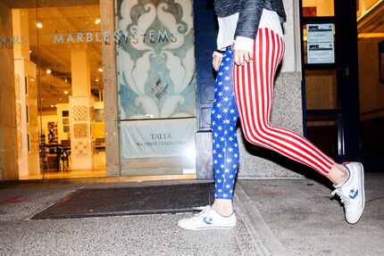 A woman wearing American flag themed pants walks to a 2016 U.S. presidential election night...