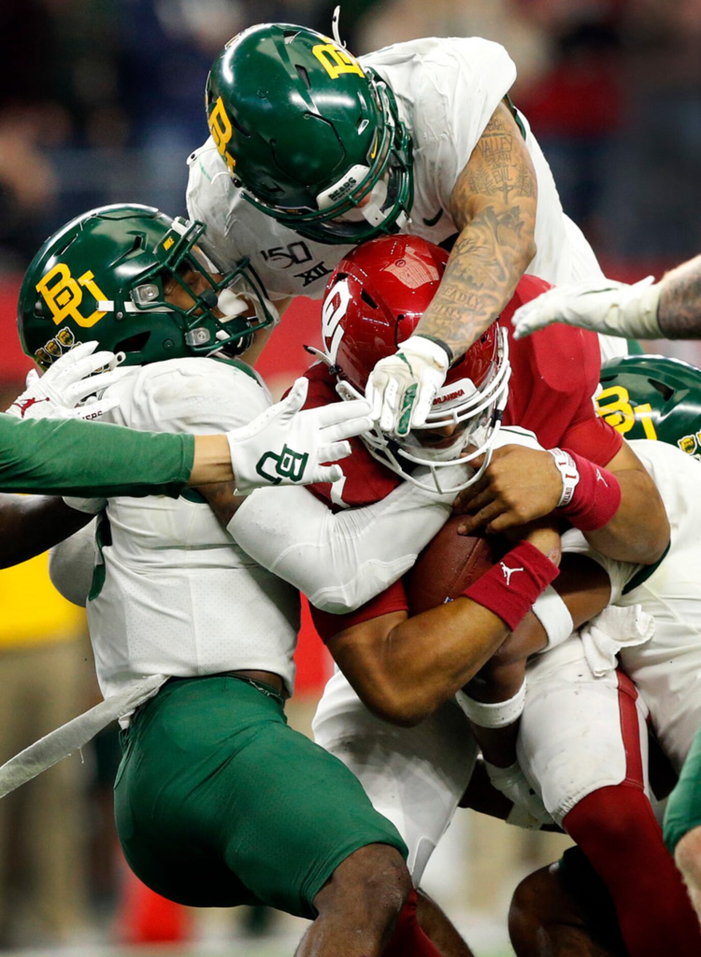 Oklahoma Sooners quarterback Jalen Hurts (1) carries a trio of Baylor Bears defenders with...