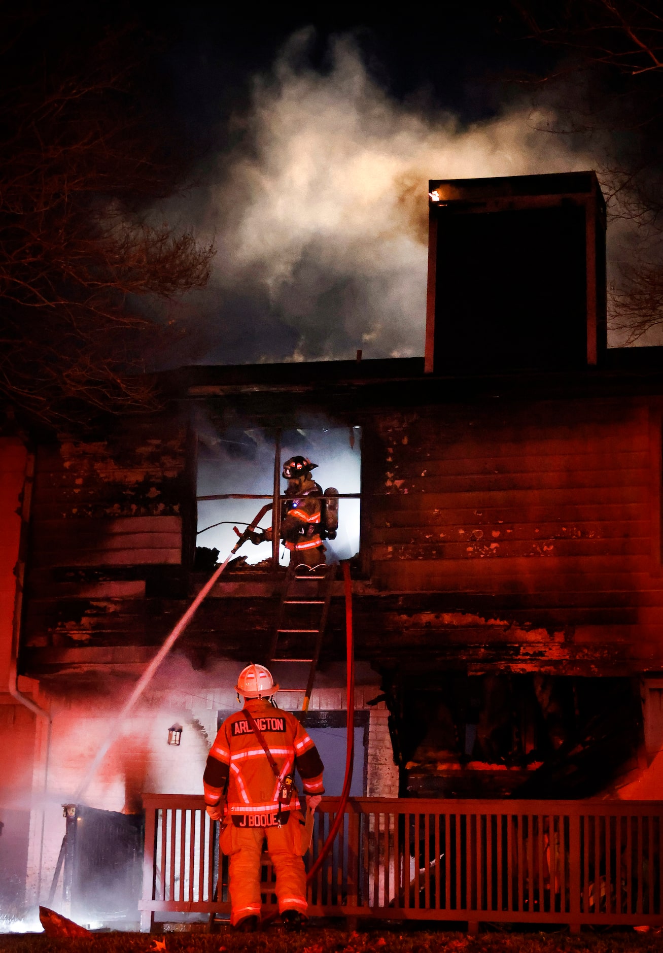 Arlington firefighters put out hot spots as they battle a two-alarm blaze at the Rise North...