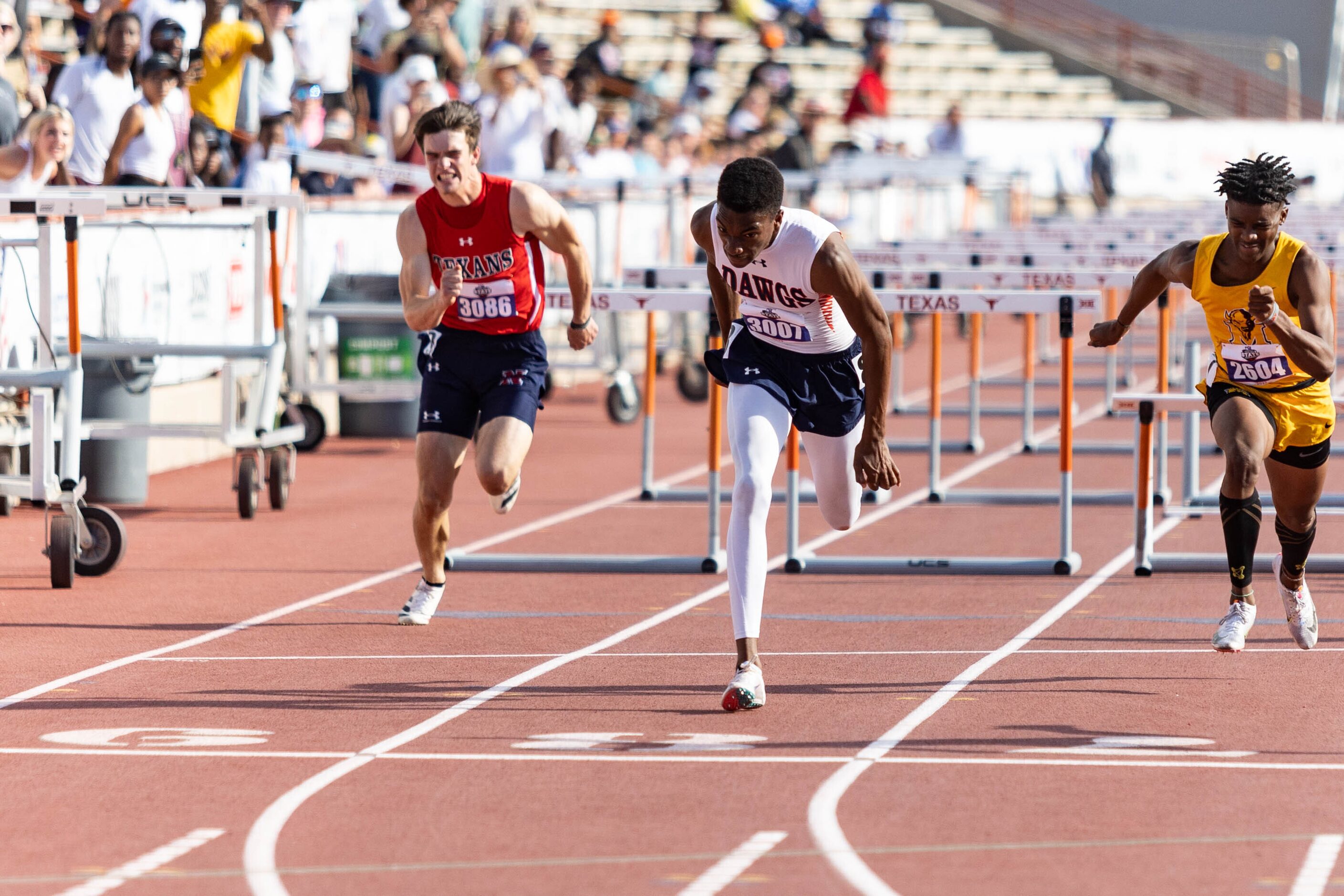 Kody Blackwood of McKinney North, center, crosses the finish line during the boys’ 110m...