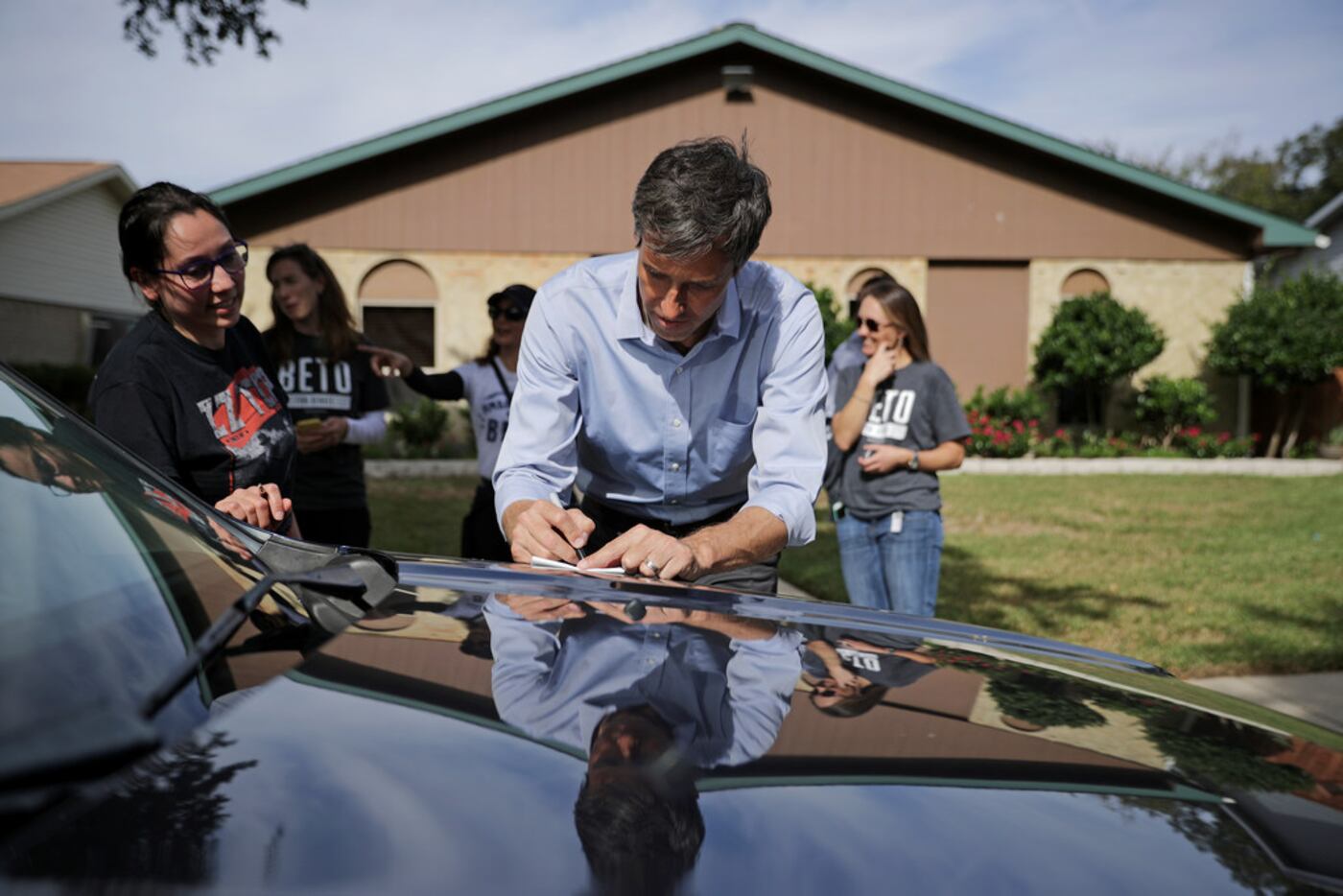 Rep. Beto O'Rourke, D-Texas, writes a message for a supporter who pulled over after seeing...