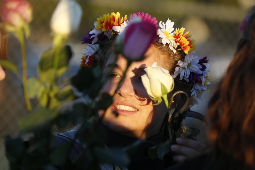 Mansfield's Jillian Anderson hides her eye behind the shadow of a flower on senior day...