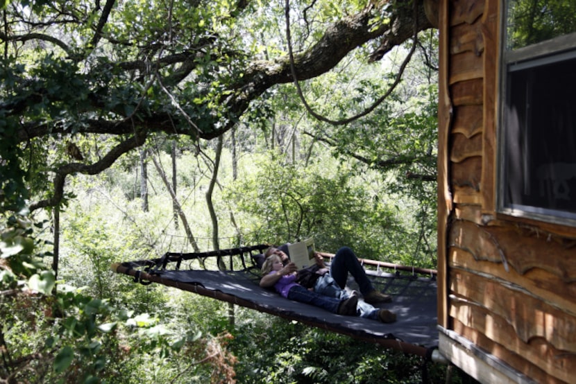 Owner Mike Snyder reads a book to his daughter, Savannah Snyder while relaxing on a platform...