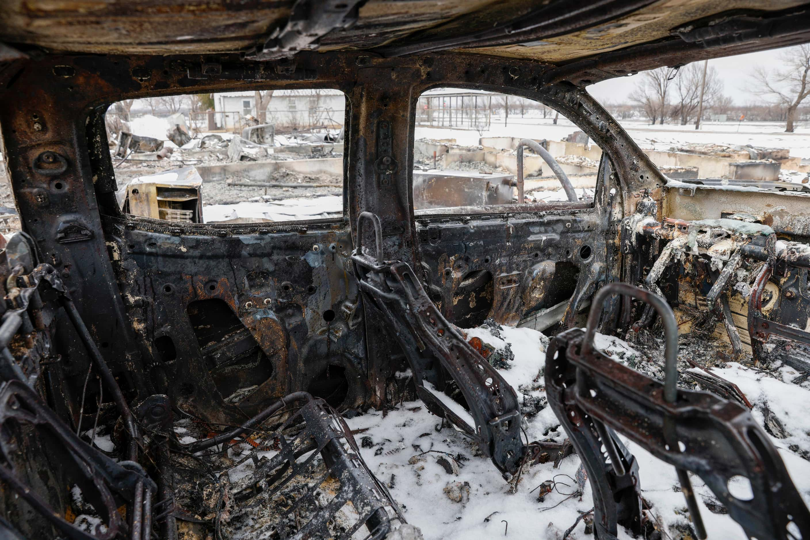 Snow covers the charred interior of a pickup truck destroyed by the Smokehouse Creek Fire,...