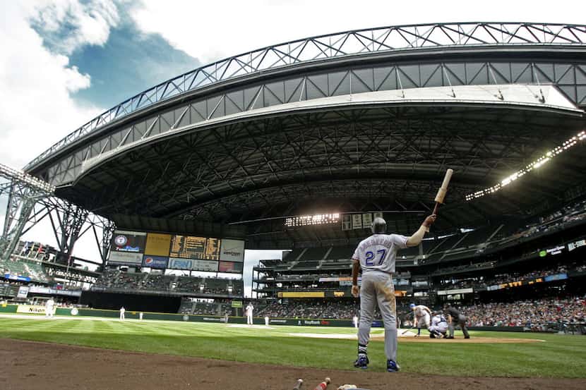 Texas' Vladimir Guerrero watches as the roof closes at Safeco Field as the skies darken with...