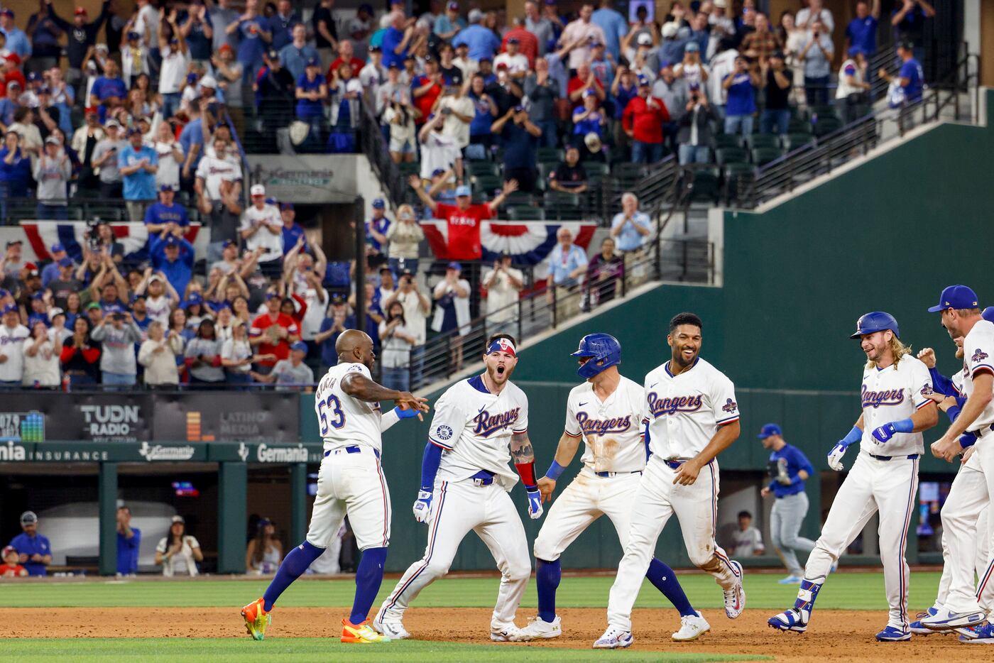 Texas Rangers catcher Jonah Heim (second from left) celebrates with teammates after his...