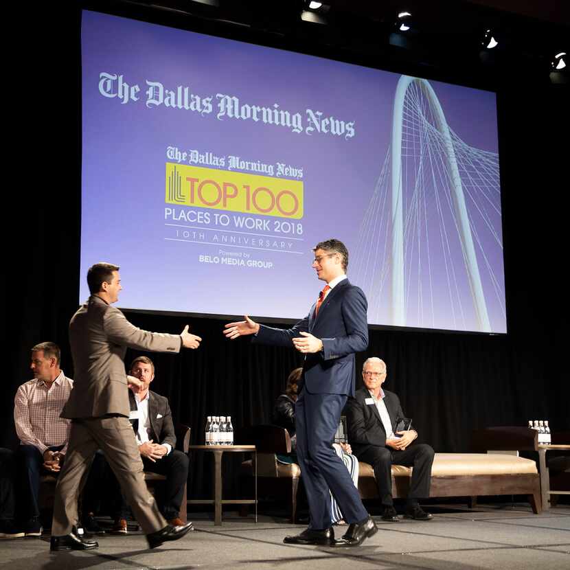 Grant Moise (right), president and publisher of The Dallas Morning News, shook hands with...