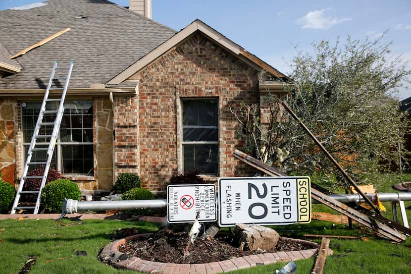 A sign lays in the yard of a home along Tannerson Drive following the storm in Rockwall....