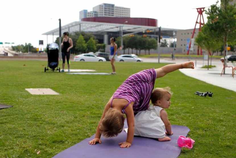 
Siena, 3, and Thea Neri, 11 months, practice yoga while their mother, Lara Neri of Irving...