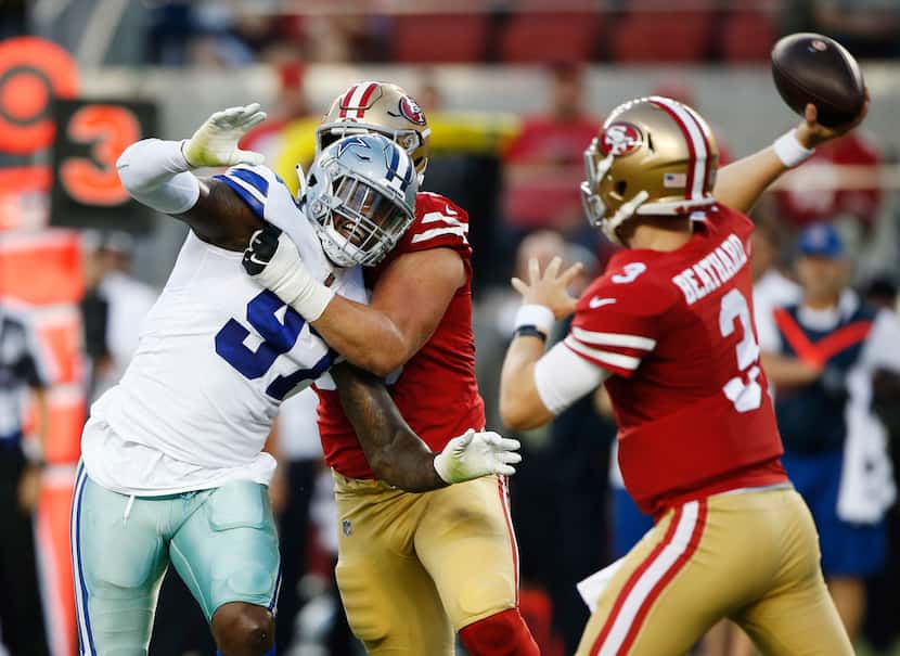 The Dallas Cowboys' Taco Charlton (97), left, is blocked by the San Francisco 49ers' Mike...