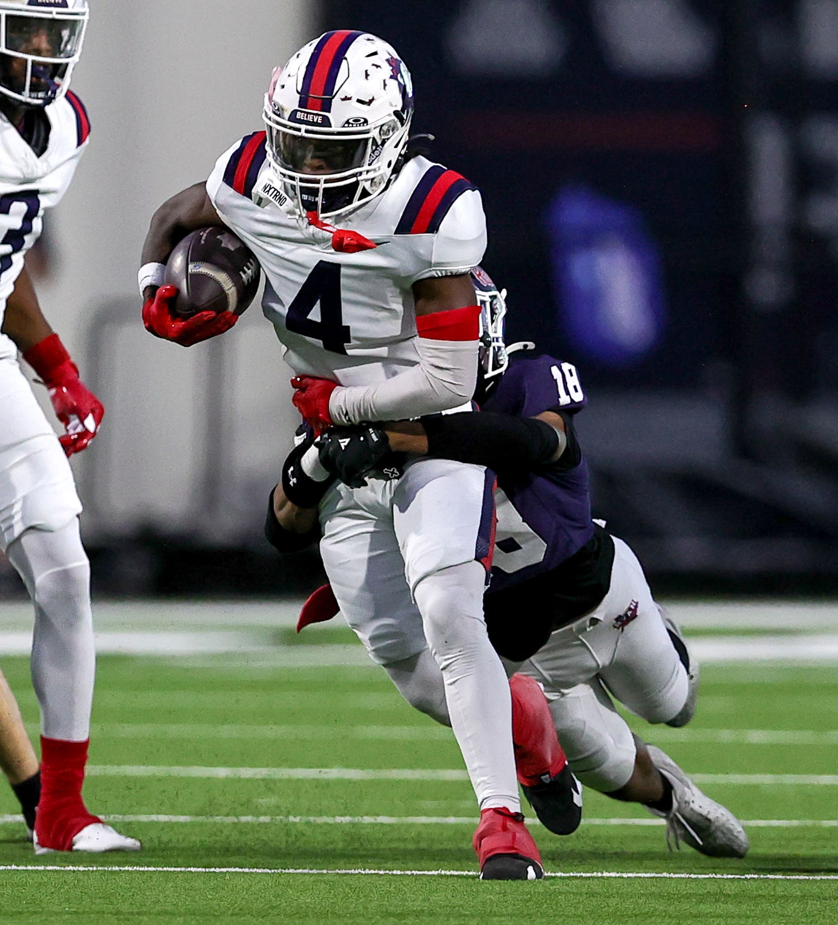 Richland wide receiver Deon Jones (4) tries to fight off a tackle from Denton Ryan's Byran...