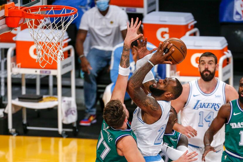 Los Angeles Lakers' LeBron James (23) goes to the basket while defended by Dallas Mavericks'...