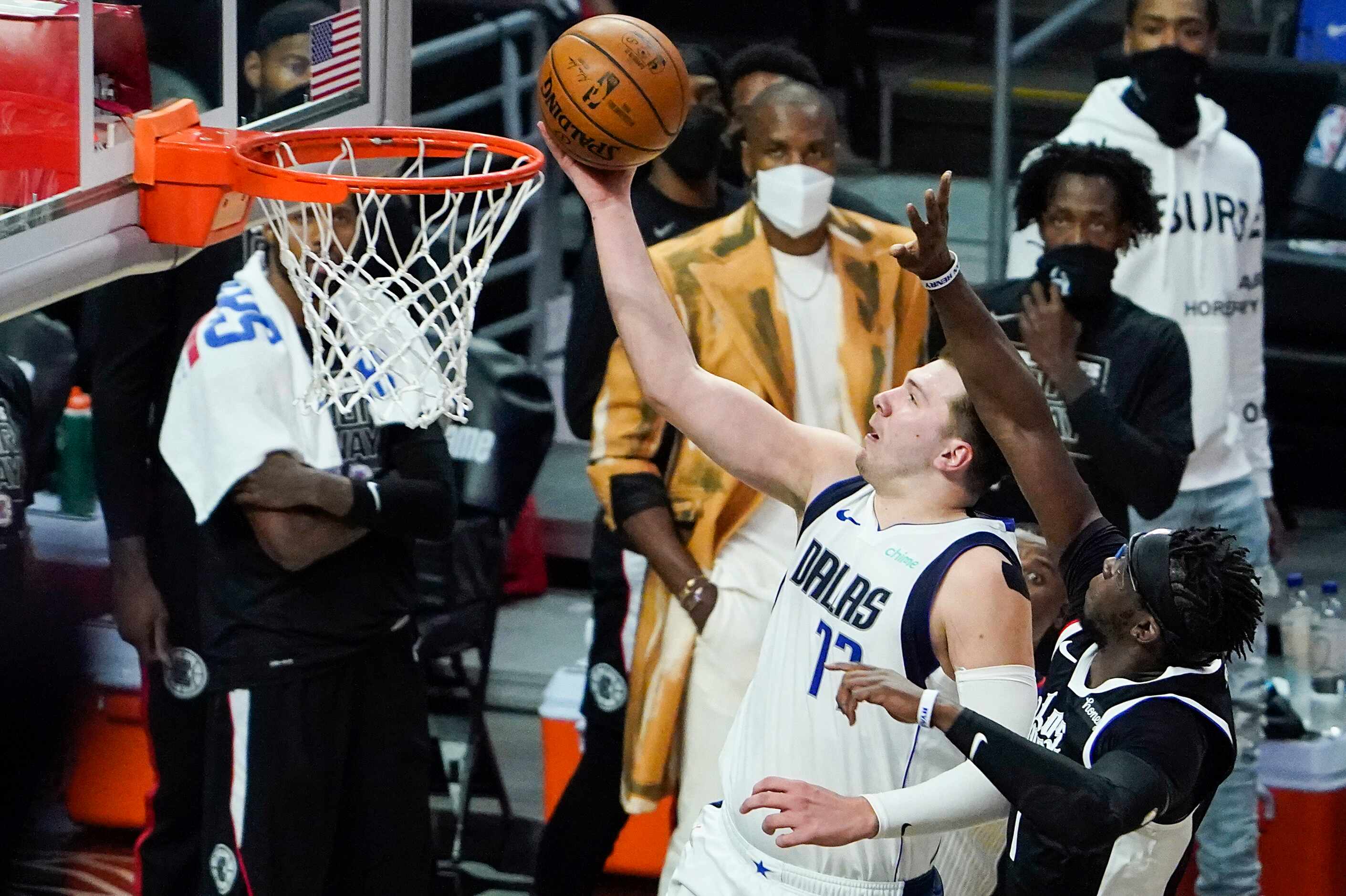 Dallas Mavericks guard Luka Doncic (77) drives for a layup past LA Clippers guard Reggie...