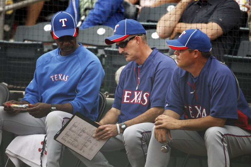 (From left) Texas Rangers manager Ron Washington and pitching coach Mike Maddux exchange...