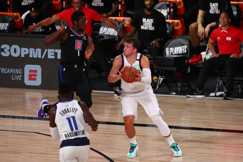 Los Angeles Clippers' guard Reggie Jackson (1) fouls Dallas Mavericks guard Luka Doncic (77)...