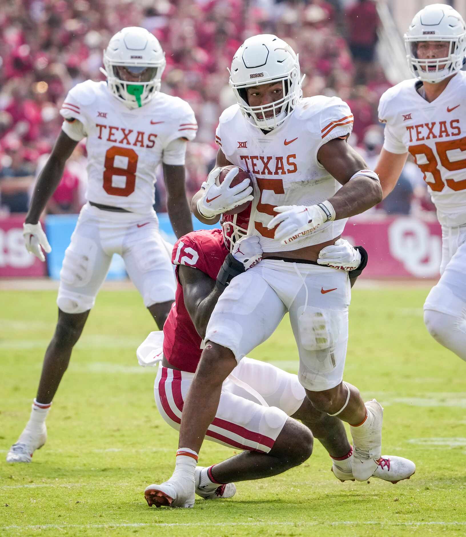 Texas running back Bijan Robinson (5) is brought down by Oklahoma defensive back Key...