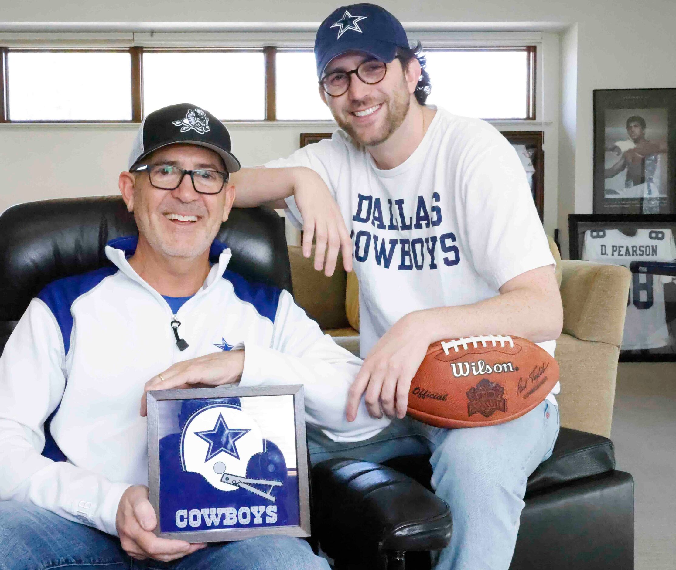 Cowboys fans Marc, left, and his son Miles Andres poses for portrait session with the...