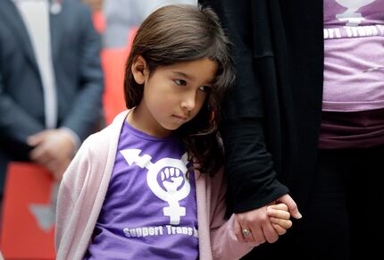 Libby Gonzales, a transgender girl, stands with her mother, Rachel, as members of the...