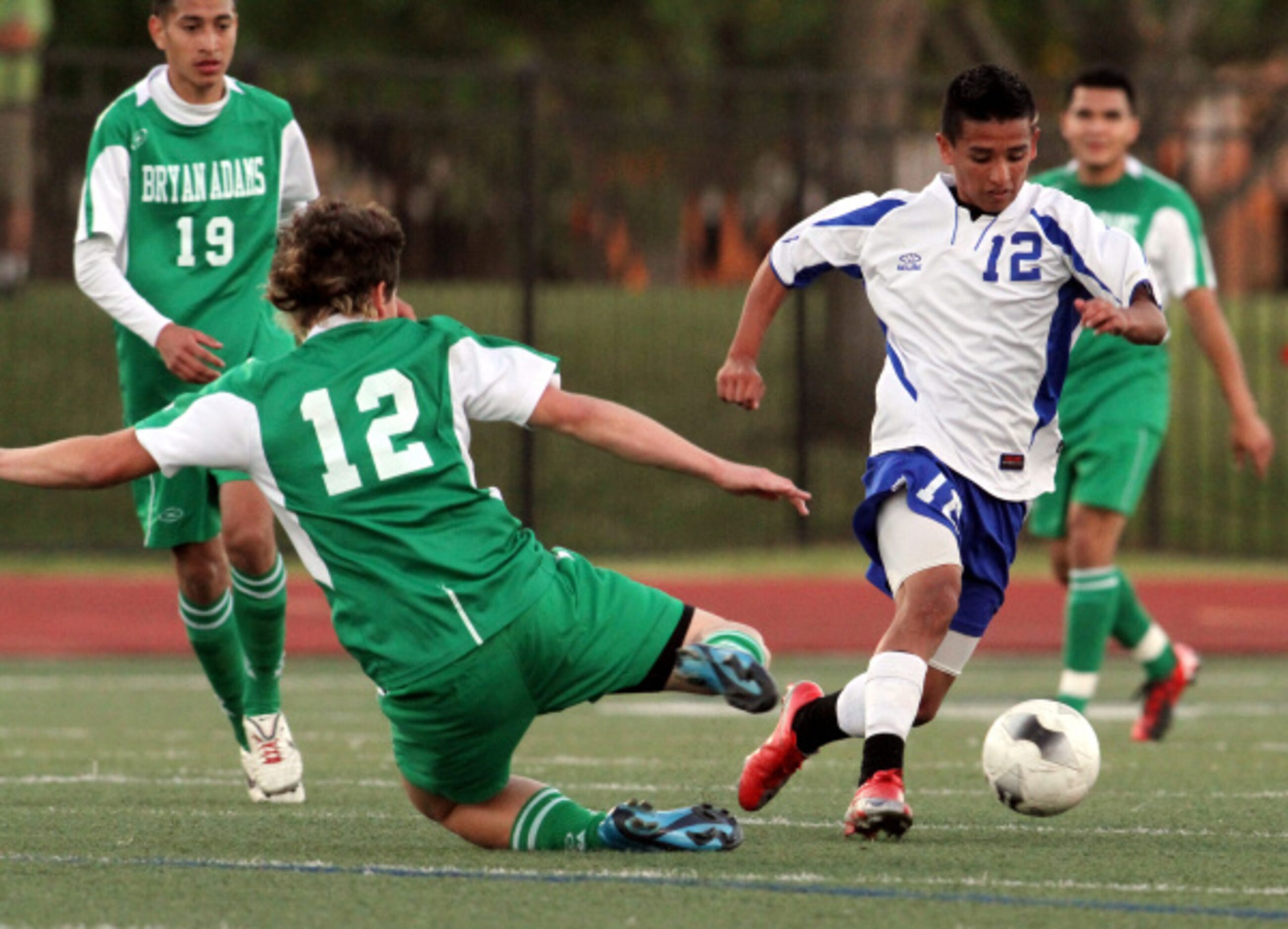 R.L. Turner's Edgar Moreno (12) dashes past the defense of Bryan Adams' Marlon Salas (12)...