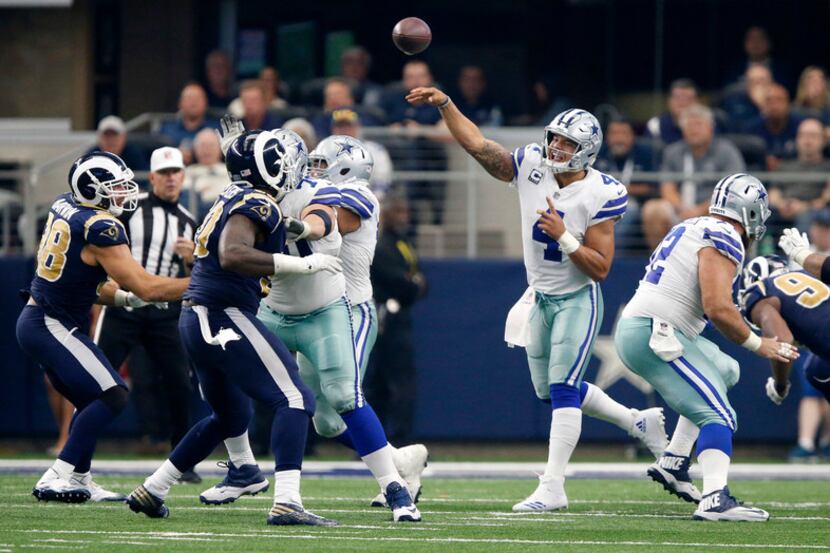 With blocking from his lineman, Dallas Cowboys quarterback Dak Prescott (4) release a pass...