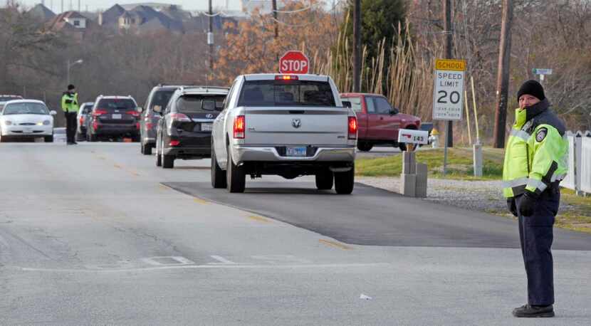 
Dallas County Sheriff Deputy M. Chavez (foreground) directs morning traffic at Collins and...