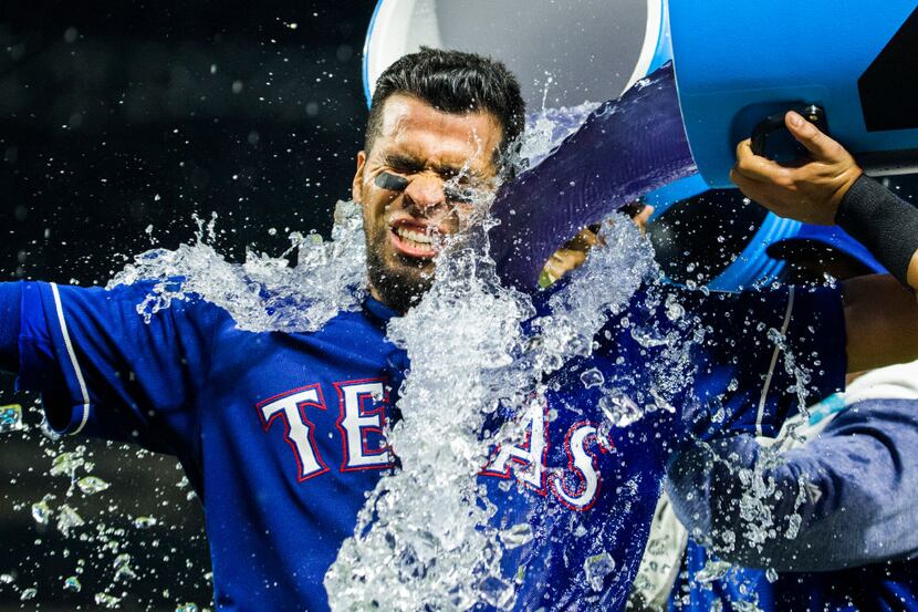 Texas Rangers catcher Robinson Chirinos (61) is dunked with a sports drink after he...