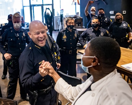 in this 2021 photo, Dallas Police Chief Eddie García talks with Cafe Momentum intern Keanna...