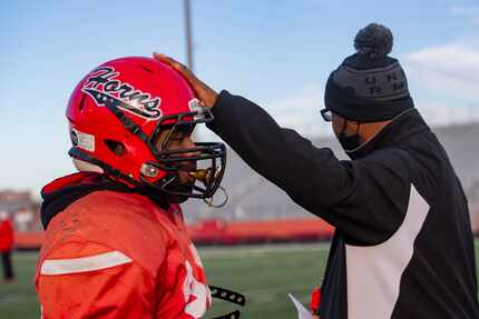 Cedar Hill coach Carlos Lynn touches Kavonte Johnson's (38) helmet during practice at...
