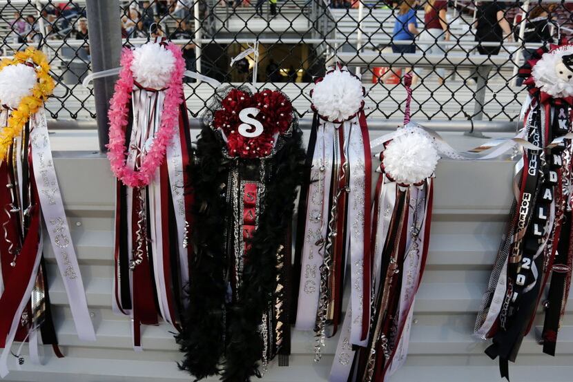 (TXHSFB) Mums hang from a fence before the start of Wylie High's Homecoming football game...