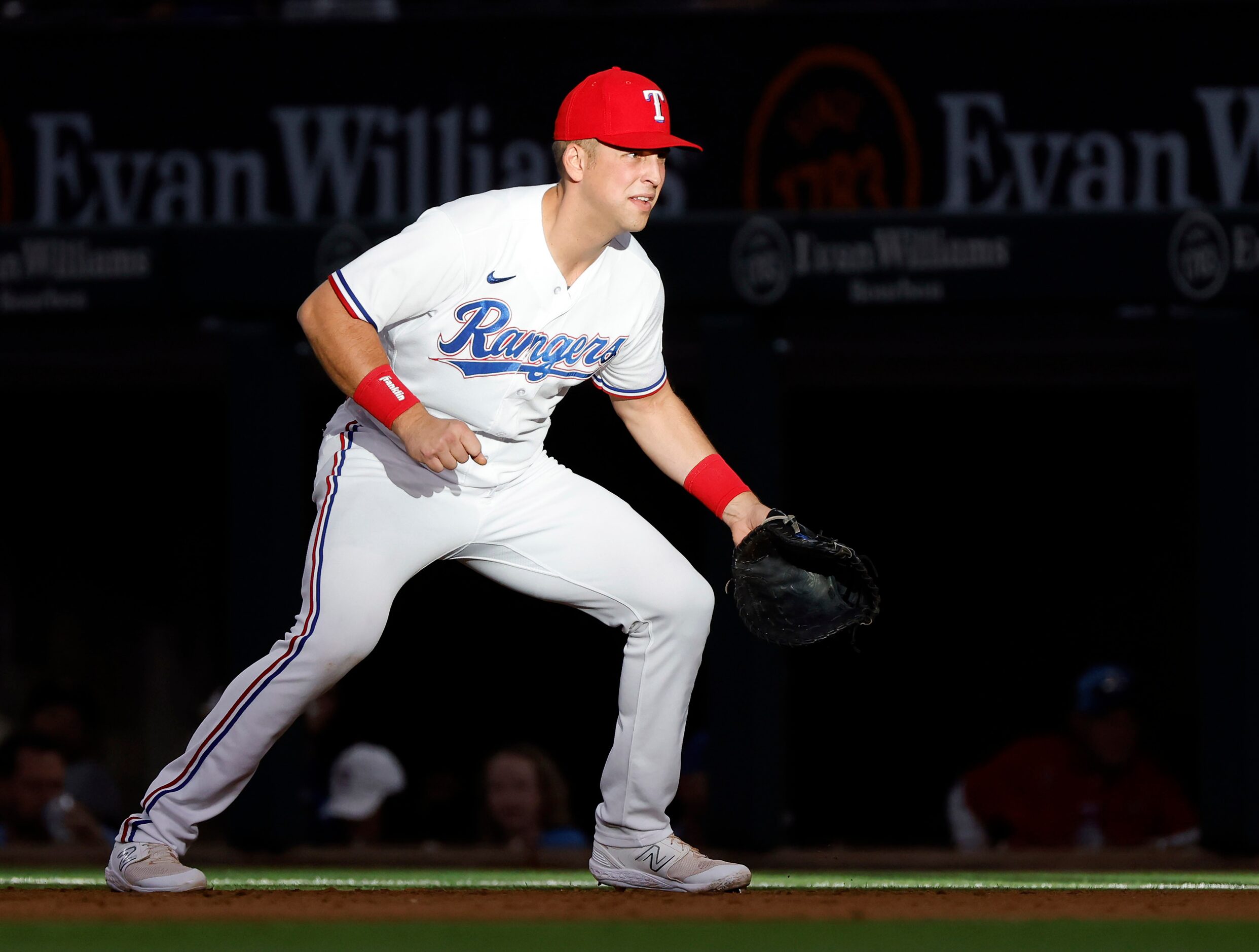 Texas Rangers Nathaniel Lowe fights the sun as he fields first base during the sixth inning...