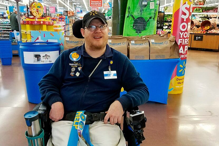 In this April 21, 2018 photo provided by Rachel Wasser, Walmart greeter John Combs works at...