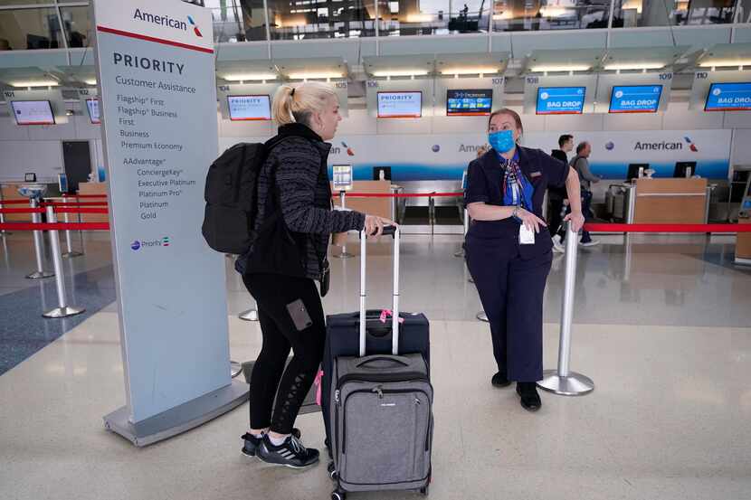 A traveler is assisted by an American Airlines employee at a ticketing gate at DFW...