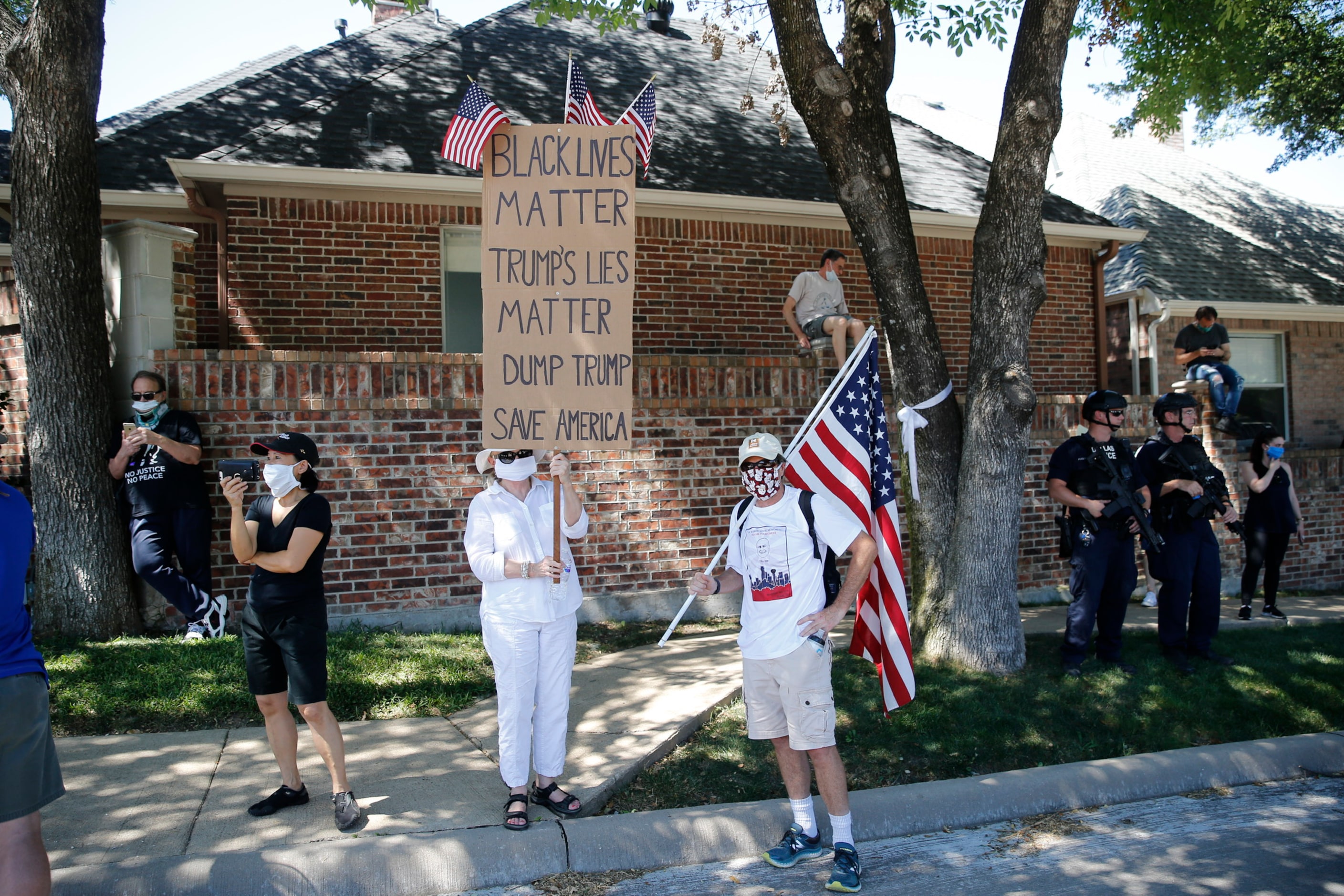 Anti-Trump protesters Dianne and Barry Smith, of Dallas, hold signs near Gateway Church in...