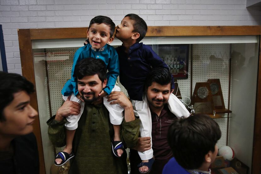 Muhammad Samana (left) of Little Elm holds onto his nephew, Ariz Samana, 4, while Bilal Khan...