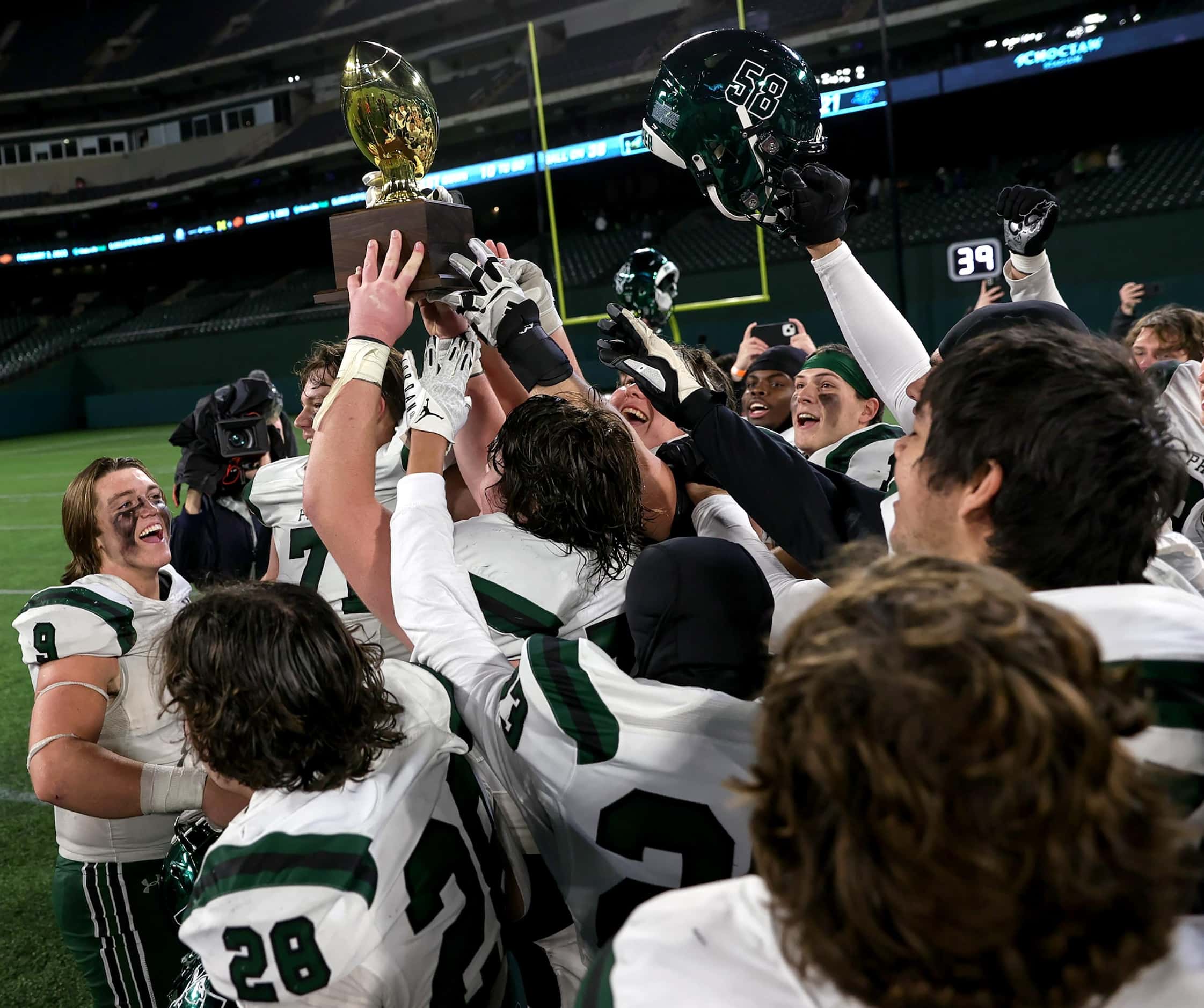 The Prosper Eagles hold up their trophy after beating North Crowley, 35-21 in the Class 6A...