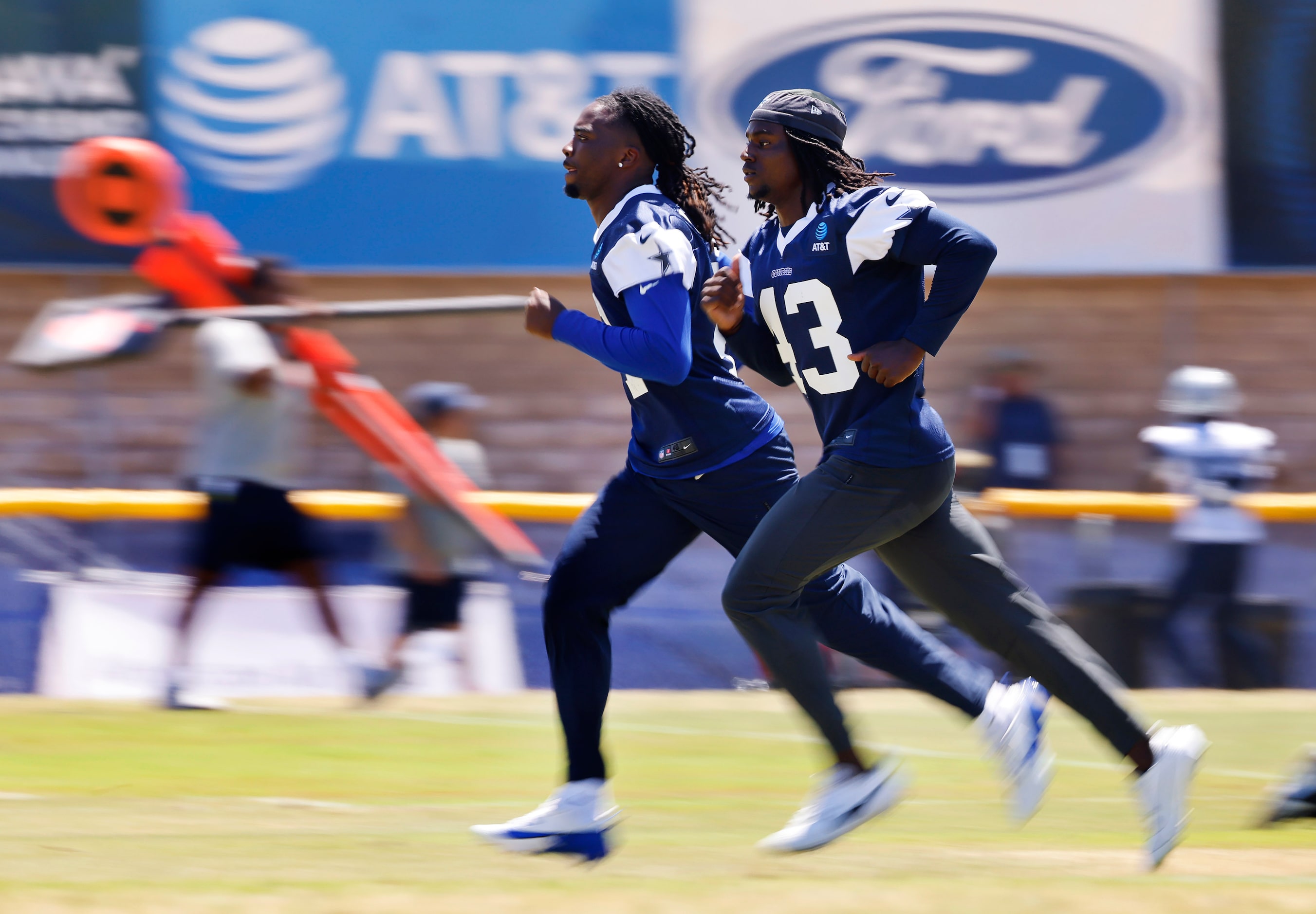 Dallas Cowboys cornerbacks Caelen Carson (left) and Kemon Hall (43) jog along the sideline...