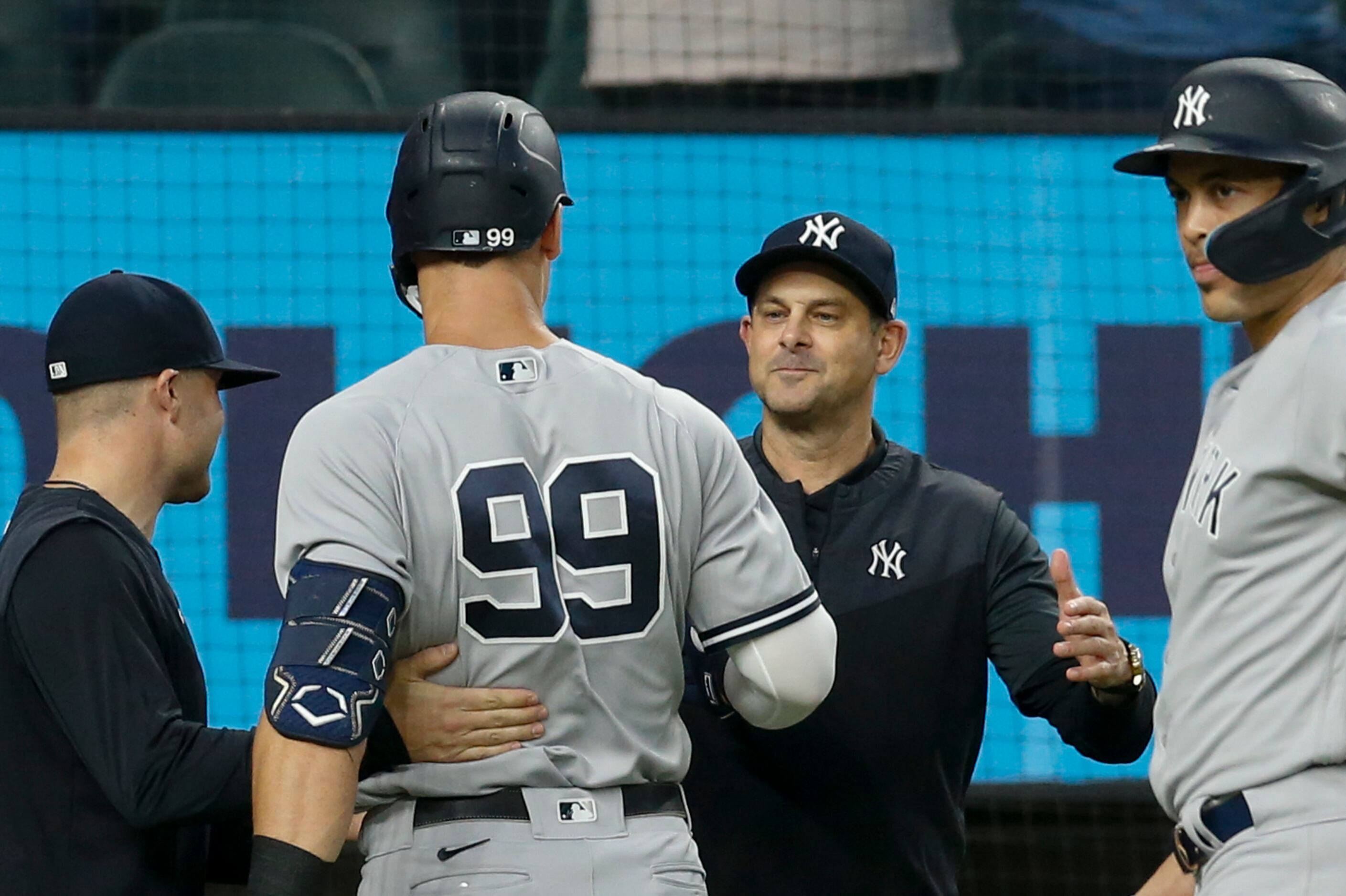 New York Yankees manager Aaron Boone (center right) congratulates right fielder Aaron Judge...
