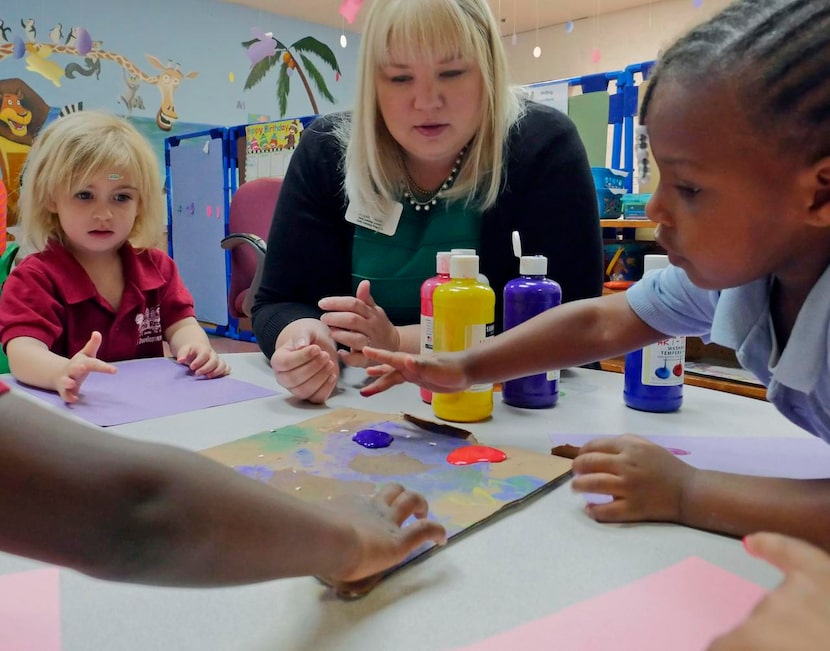 
Ember Davis, 3 (left) waits her turn as Angela Swindell (center) watches Caleiyah Davis, 3,...