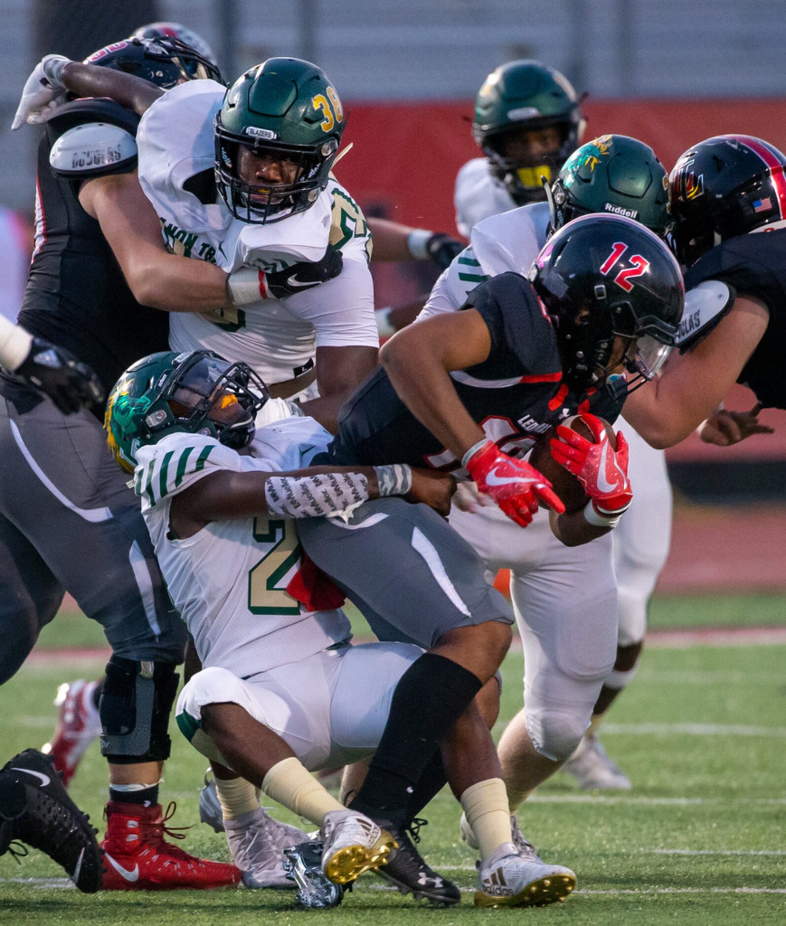 Lovejoy quarterback Noah Naldoo (12) gets tackled by Lebanon Trail line backer Jordan Hogg...