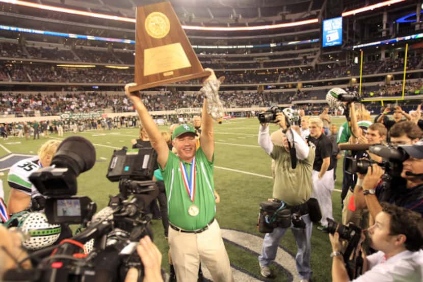 Southlake Carroll coach Hal Wasson holds the championship trophy high after the Dragons...