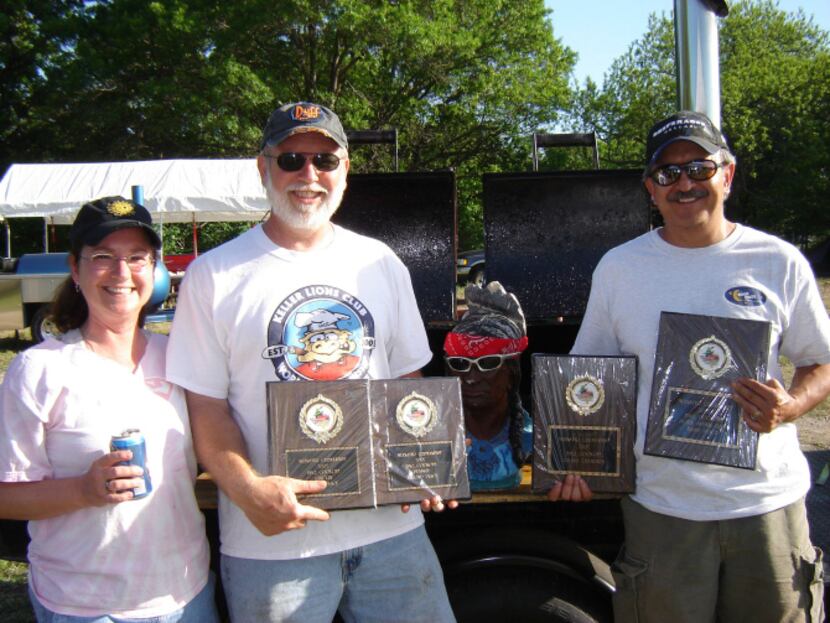 Suzan and Steve Mayberry and David Calvery display trophies won at a Muenster barbecue...