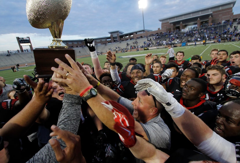 Mansfield Legacy football coach Chris Melson and his players celebrate a win over North...